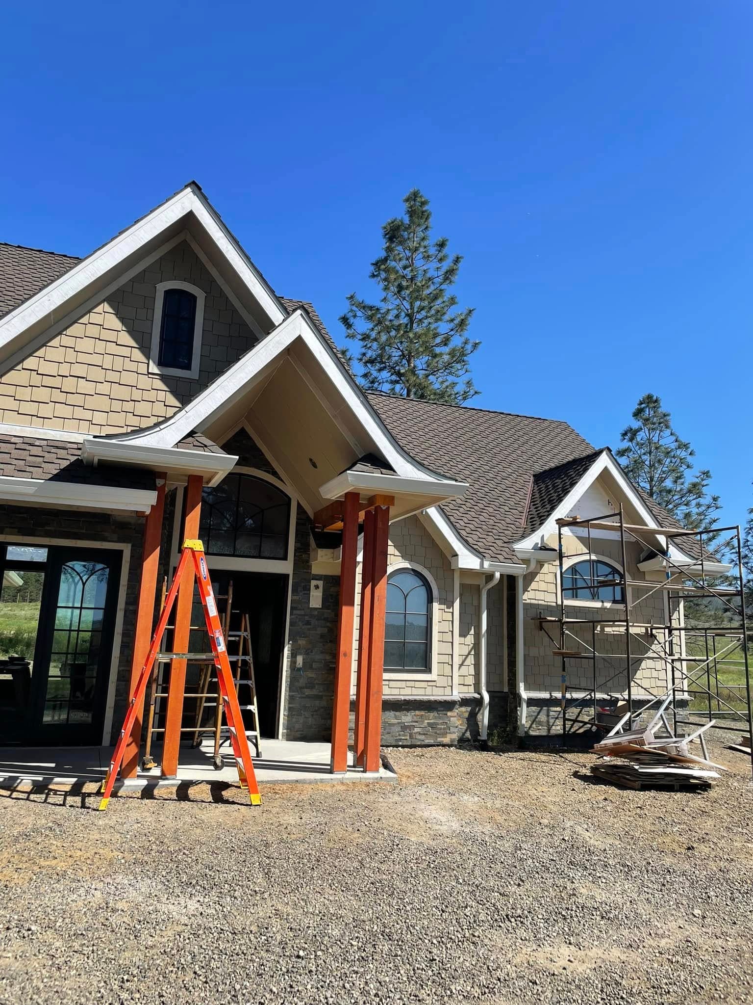 Custom craftsman home entry with cedar columns, stone base, and arched windows